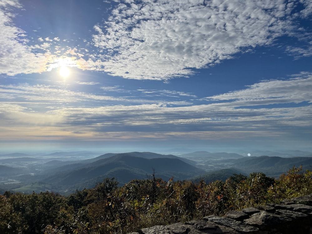 the sun is shining over the mountains in the distance