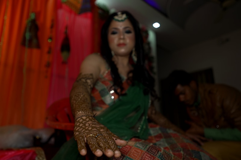 a woman with henna on her hand and a man in the background