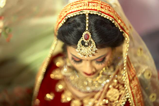 a woman in a red and gold bridal outfit