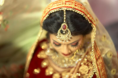 a woman in a red and gold bridal outfit