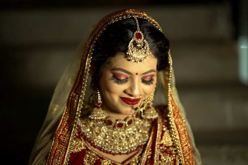 a woman in a red and gold bridal outfit