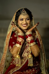 a woman in a red and gold bridal outfit