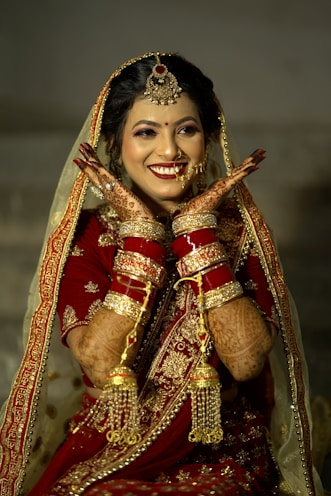 a woman in a red and gold bridal outfit