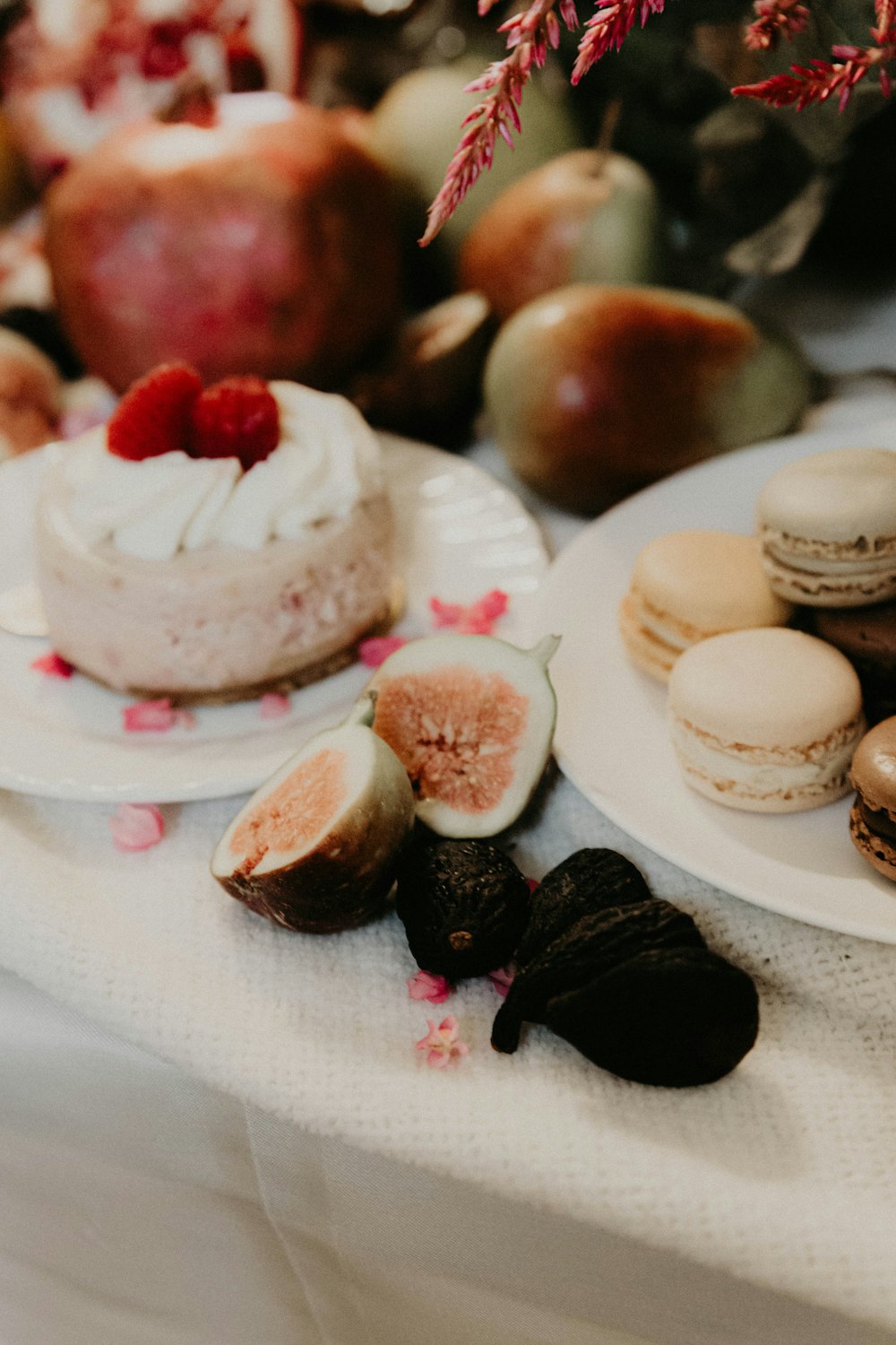 a table topped with plates of food next to a vase of flowers