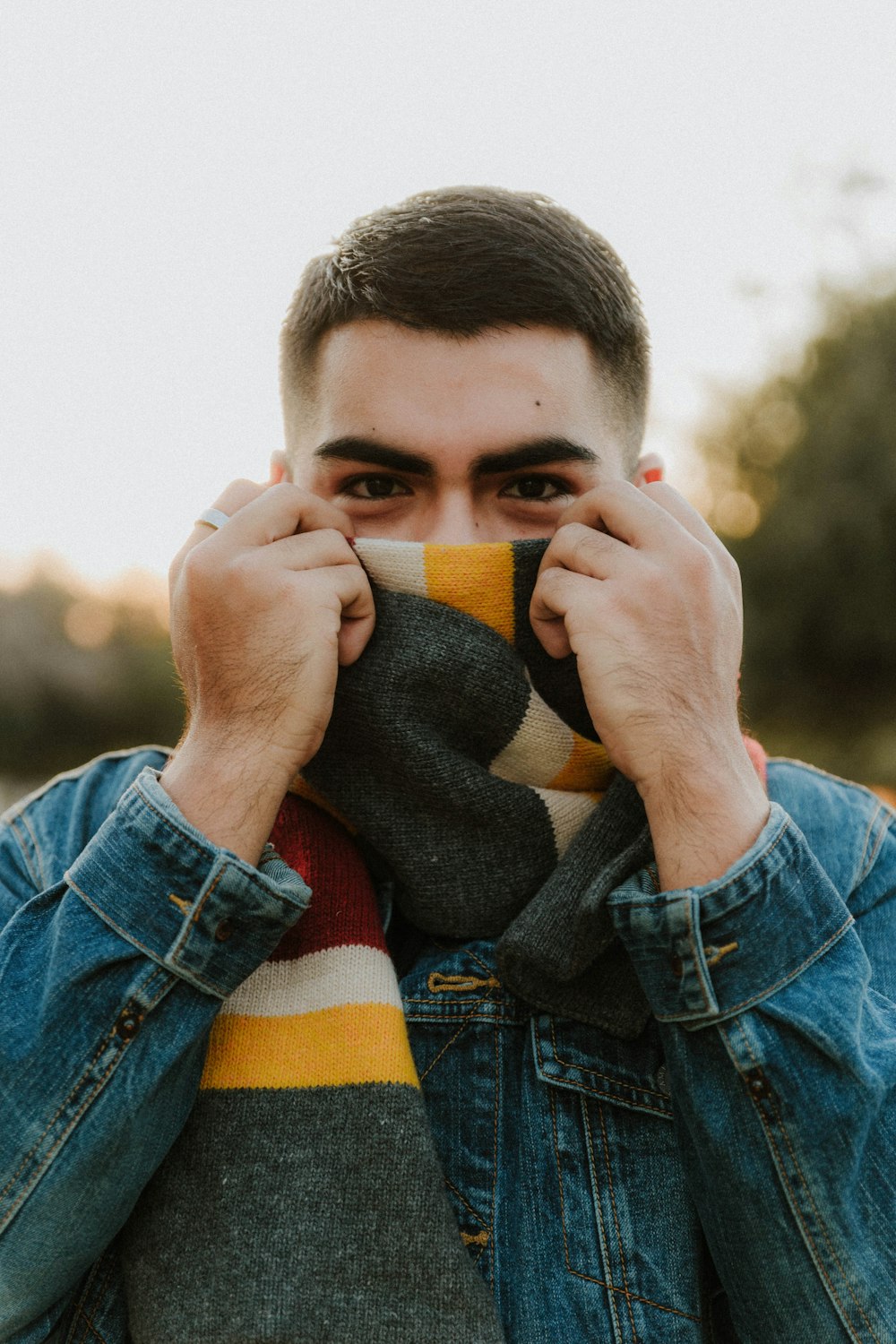 a man covering his face with a scarf