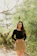 Young woman smiling outdoors surrounded by lush greenery, symbolizing hope and sustainability.