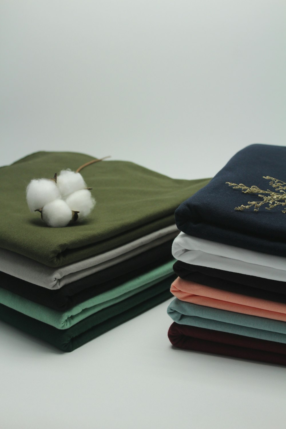 a stack of folded cloths with a cotton ball on top
