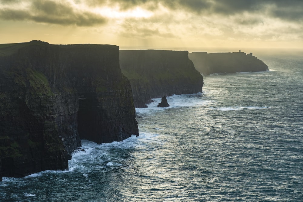 a large body of water next to a rocky cliff