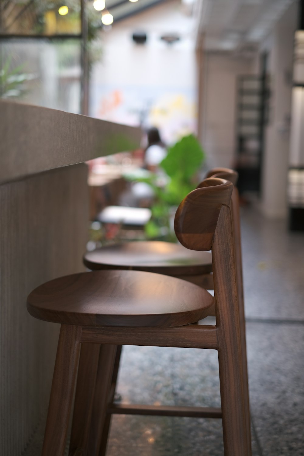 a row of wooden stools sitting next to a wall