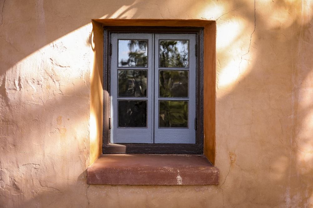a window in a stucco wall with a window sill