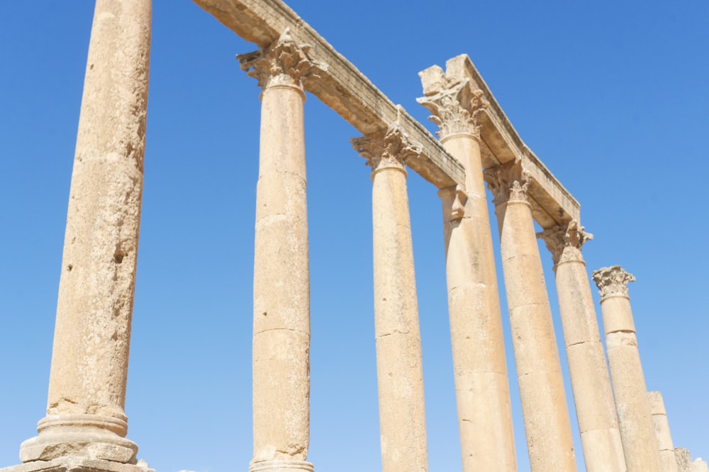 a row of stone pillars against a blue sky
