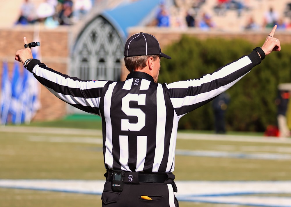 a referee standing on a field with his hands in the air