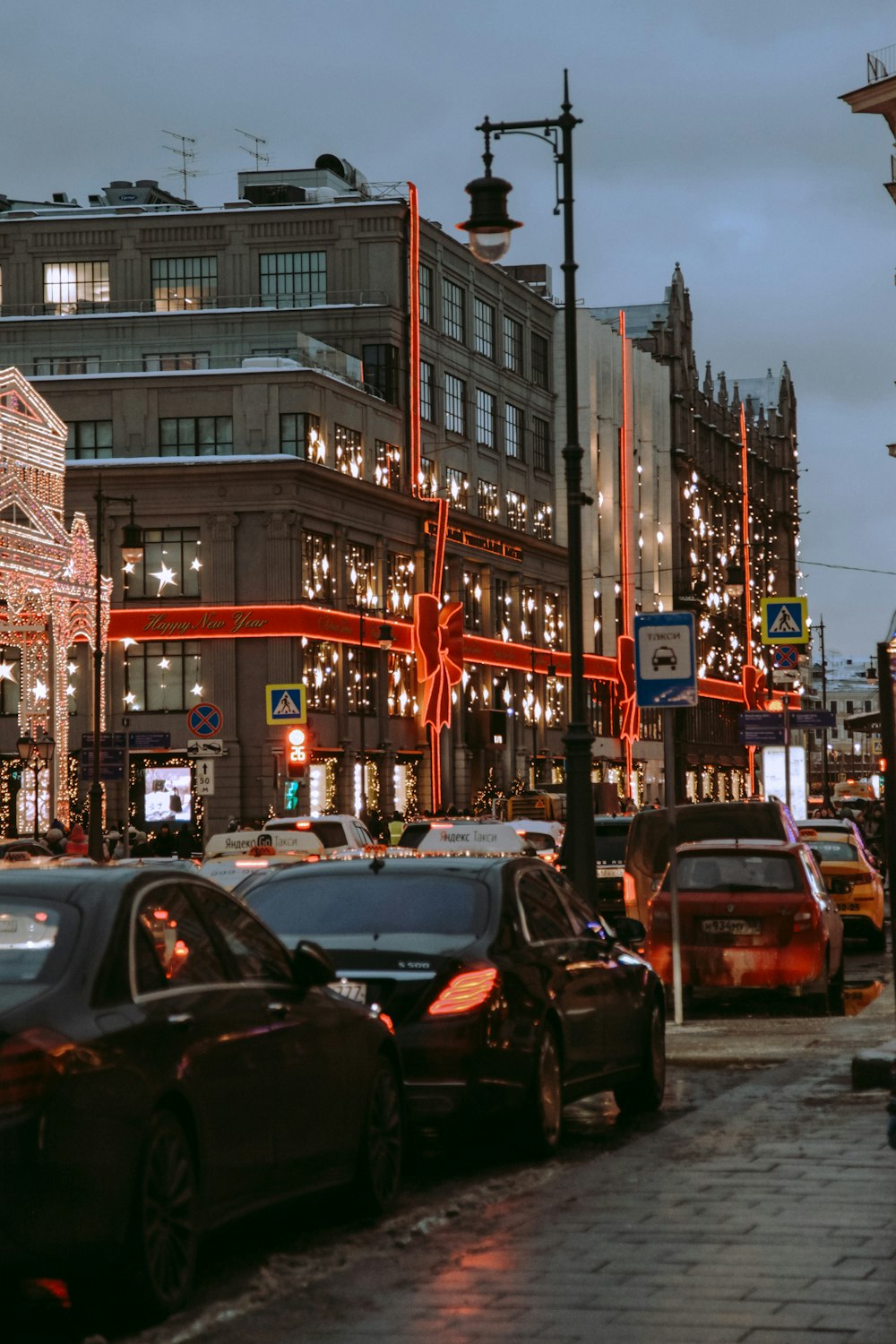 a city street filled with lots of traffic next to tall buildings