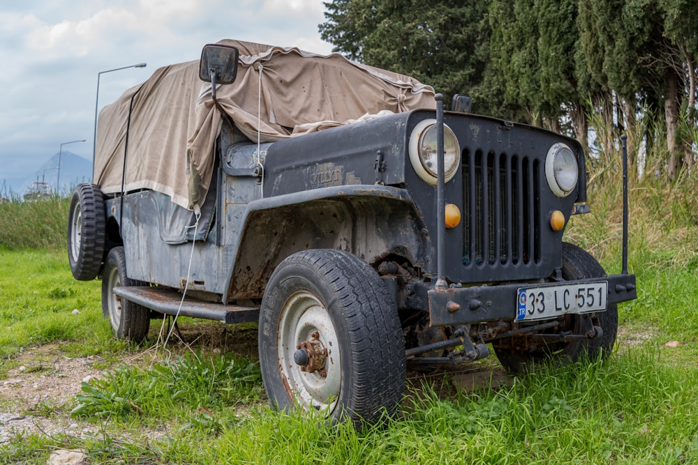 an old truck with a tarp on top of it