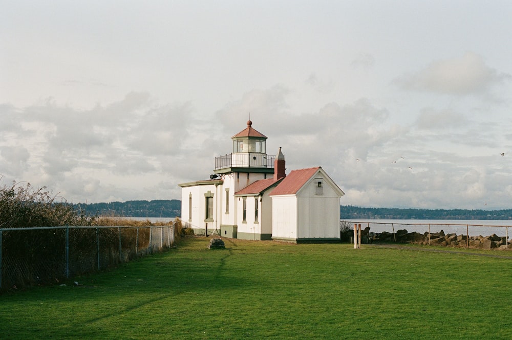 a small white building sitting on top of a lush green field