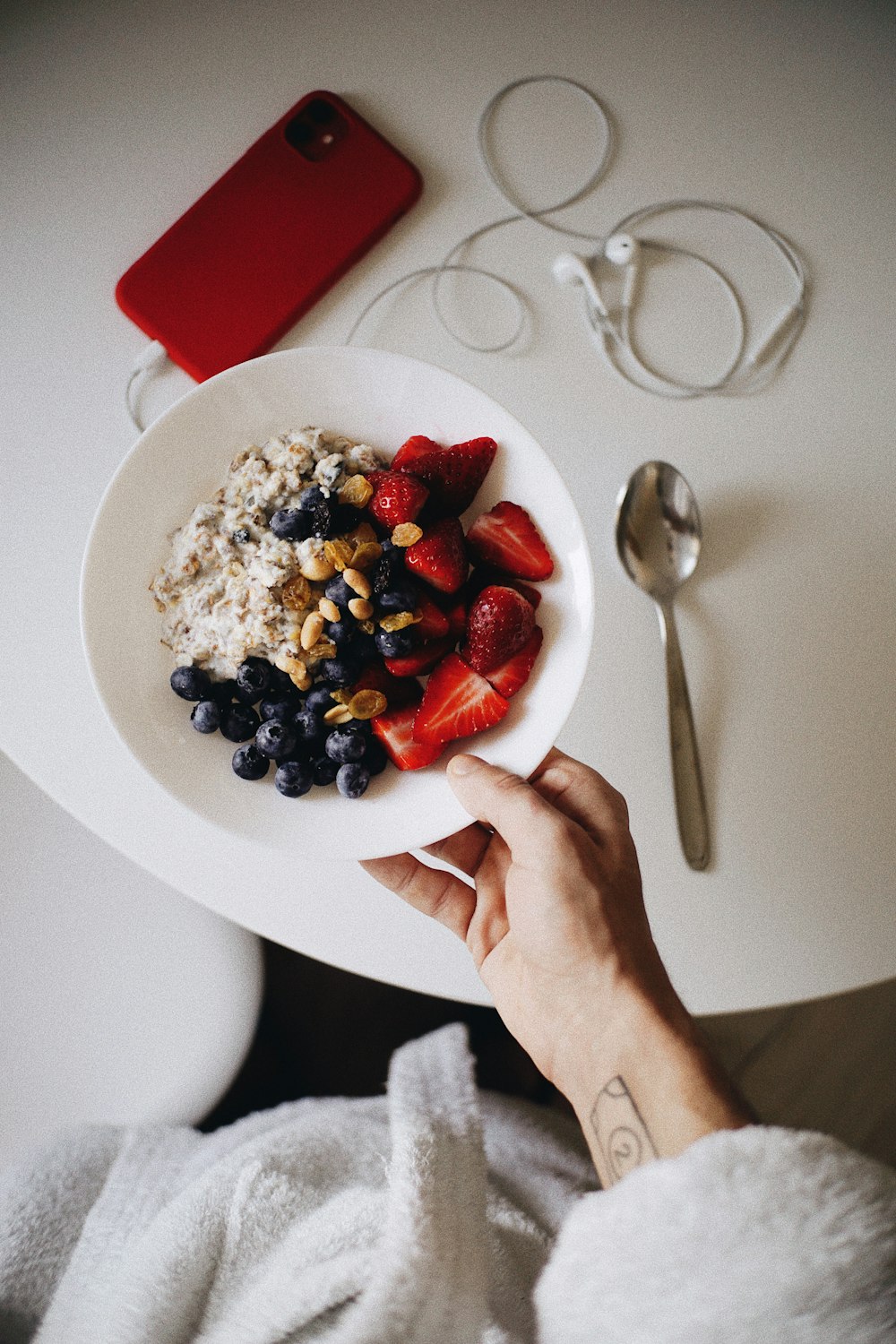 a bowl of oatmeal with strawberries and blueberries