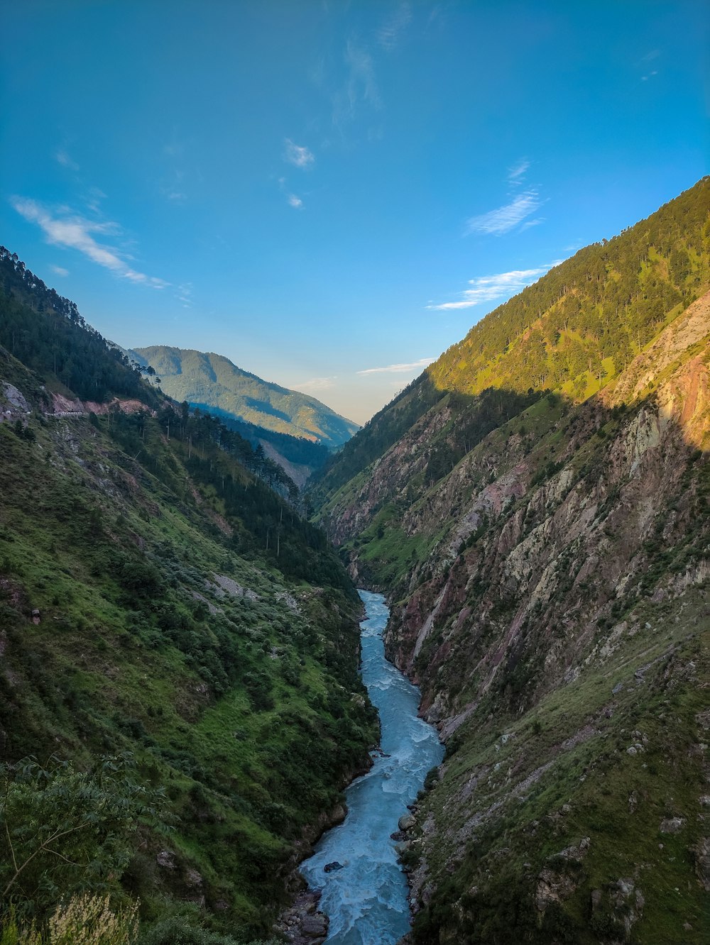 a river flowing through a lush green valley