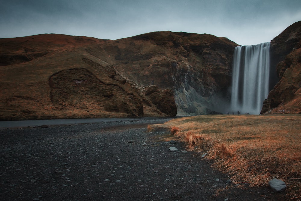 a very tall waterfall in the middle of a field
