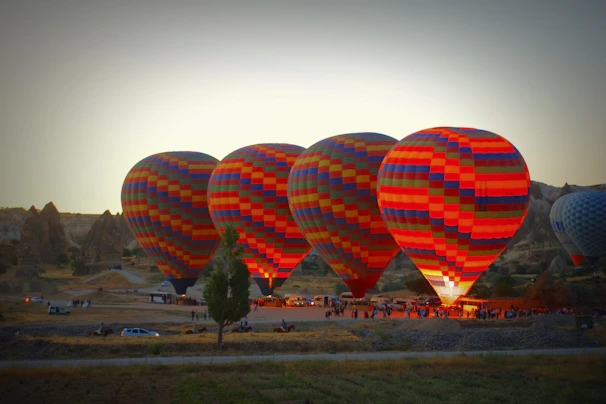 Colorful hot air balloons preparing for takeoff on a clear blue morning