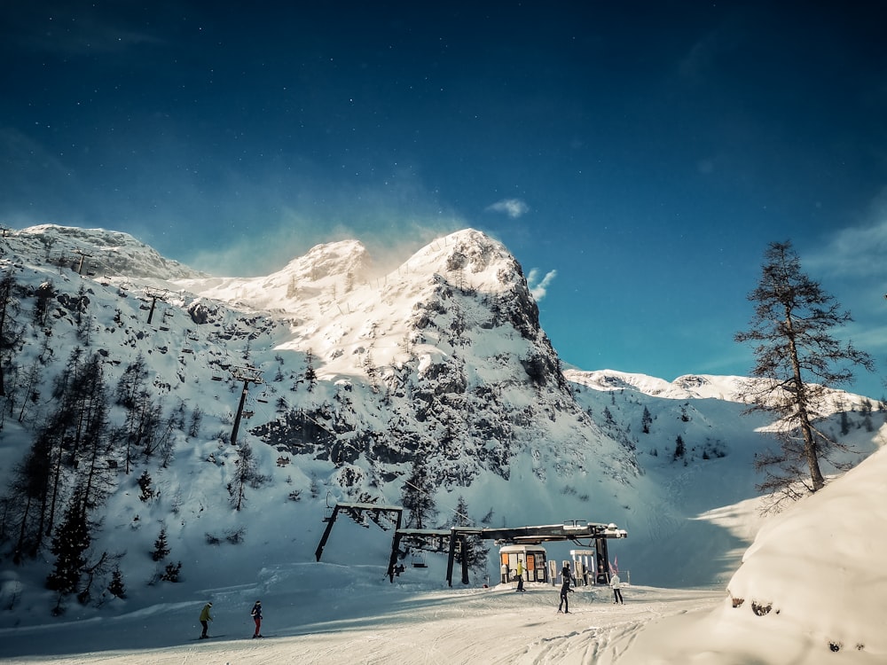 a group of people standing on top of a snow covered slope