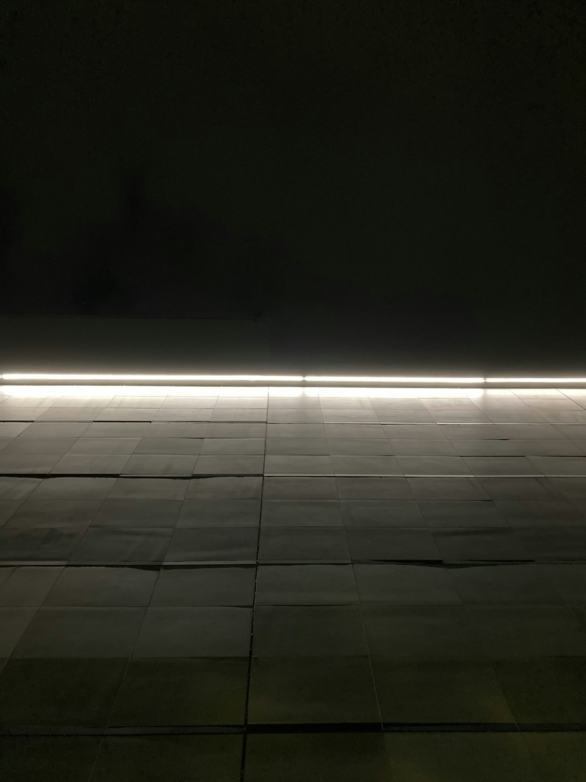 a room with a tile floor and a neon light
