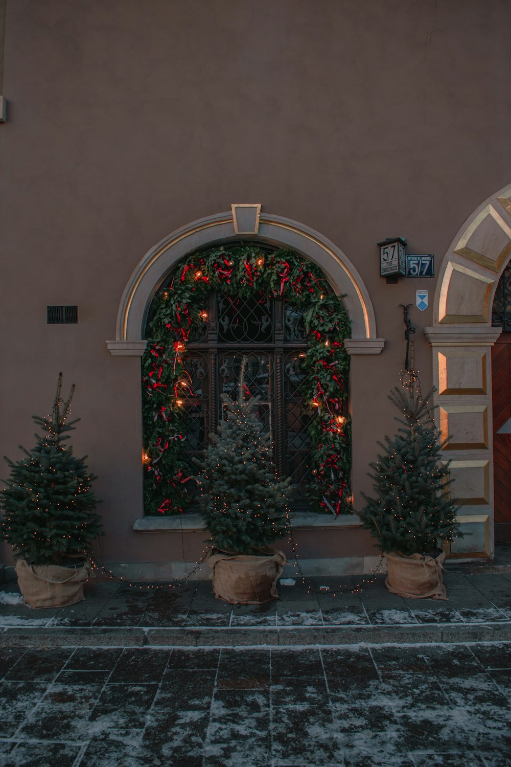 a couple of potted trees sitting in front of a building