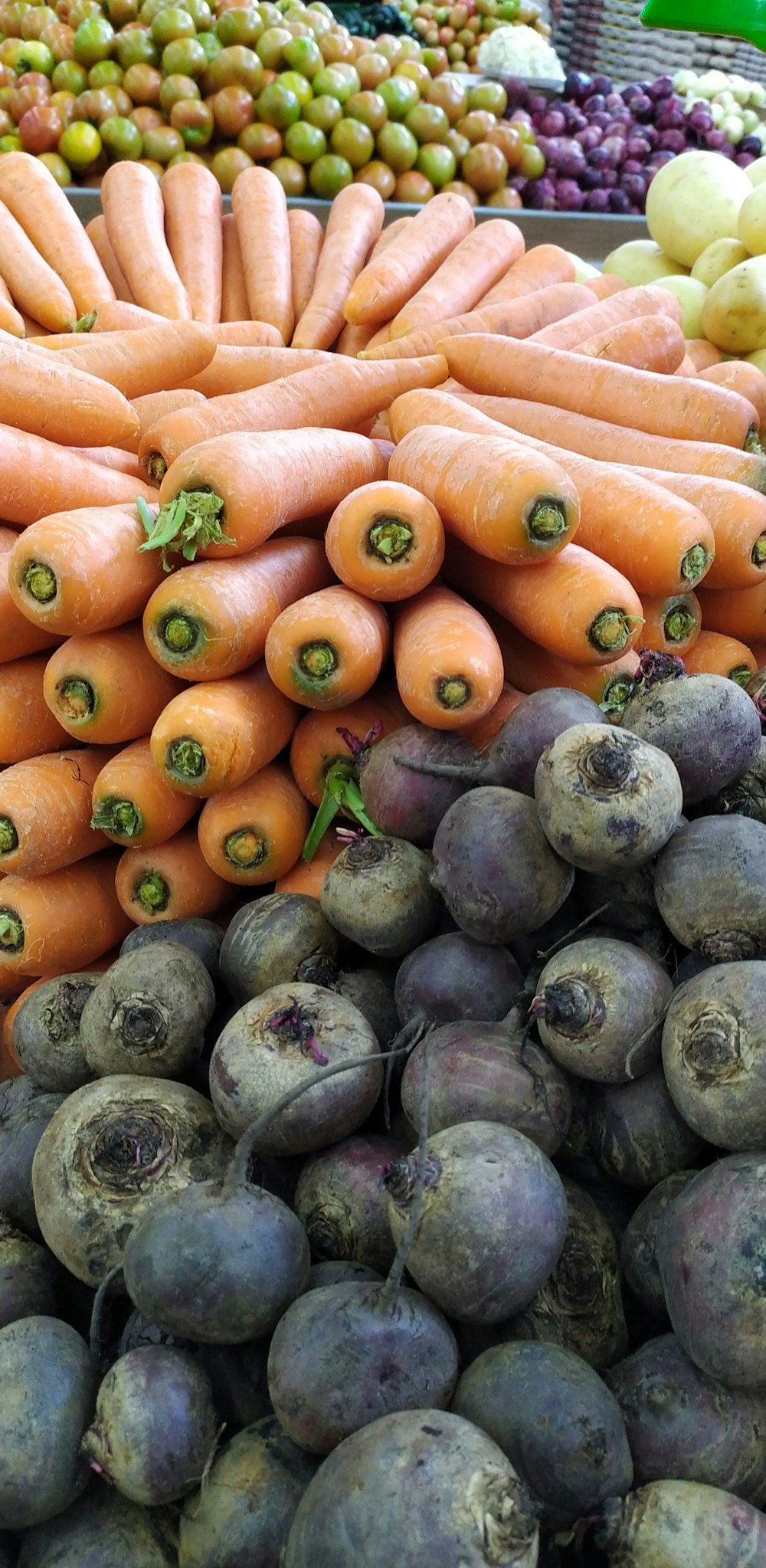 un tas de carottes assis à côté d’autres fruits et légumes