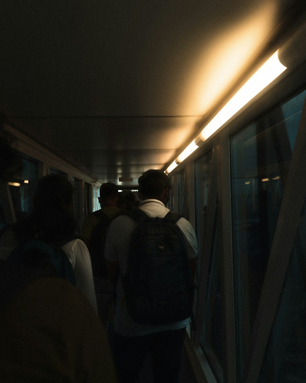 a group of people walking down a long hallway