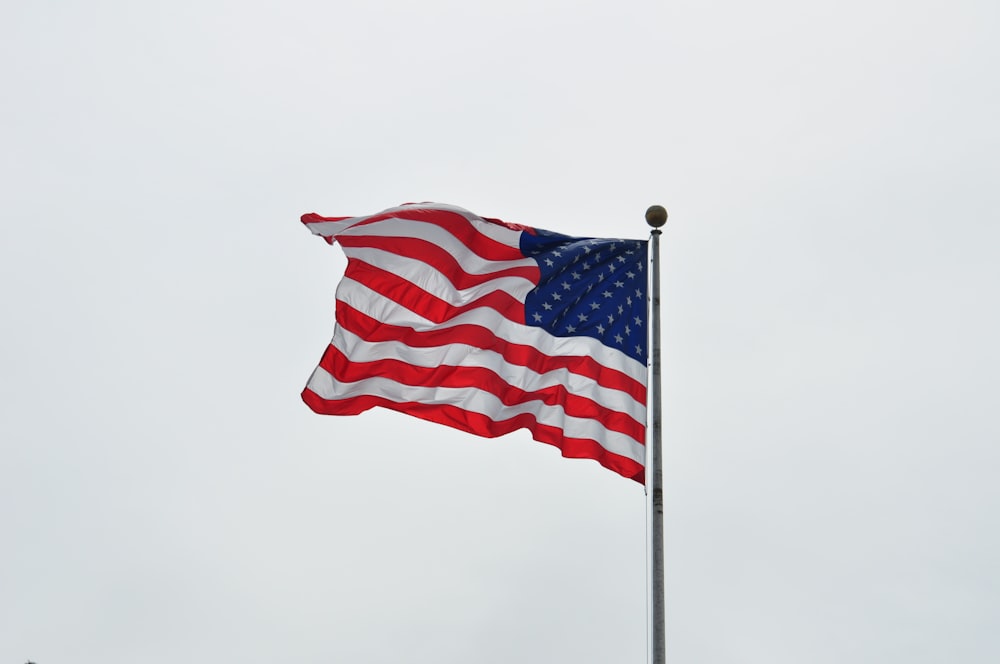 a large american flag flying in the wind