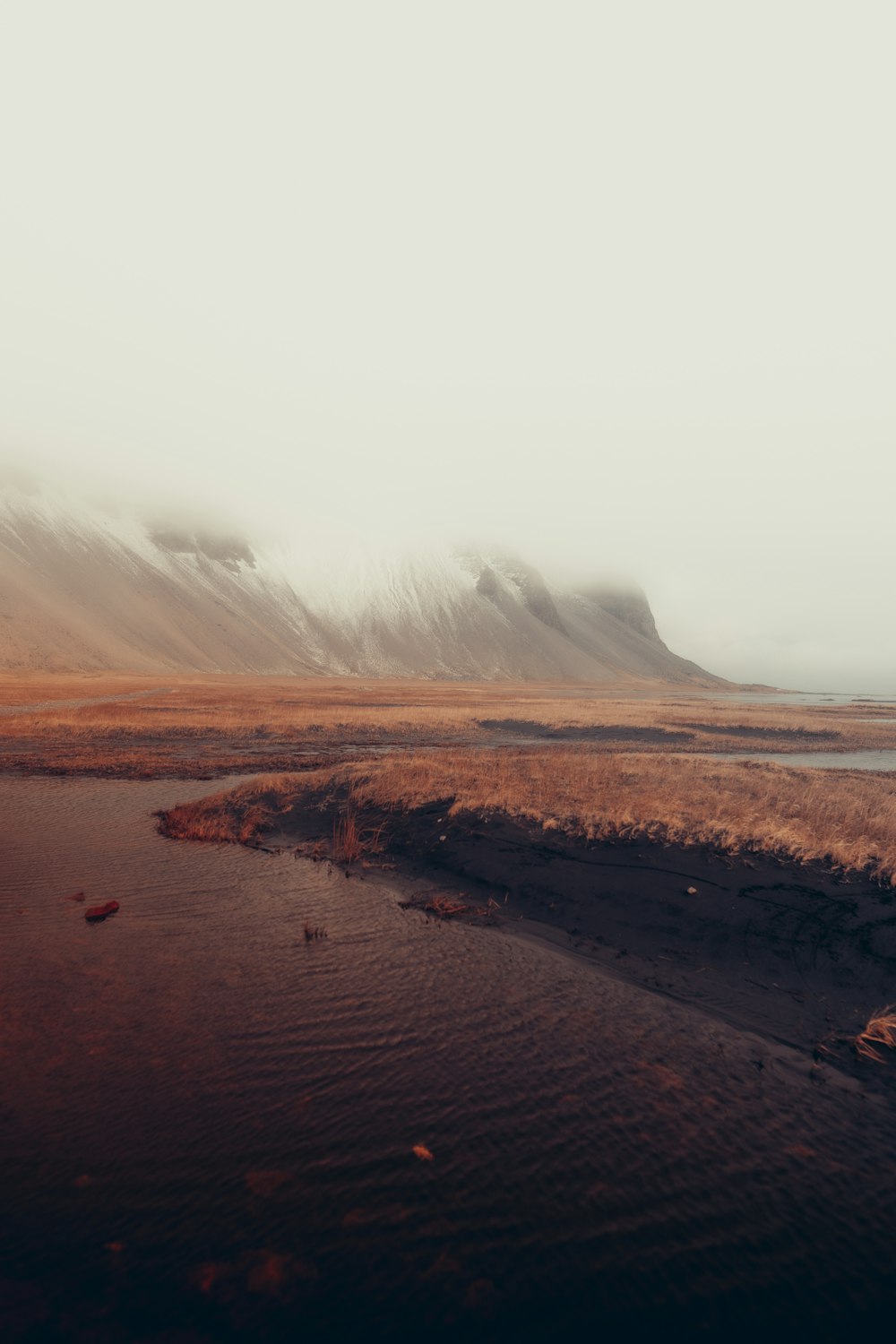 a body of water with a mountain in the background