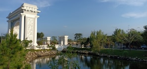 A serene ceremony area framed by tall trees and soft beige drapery, capturing the harmony of nature and design.