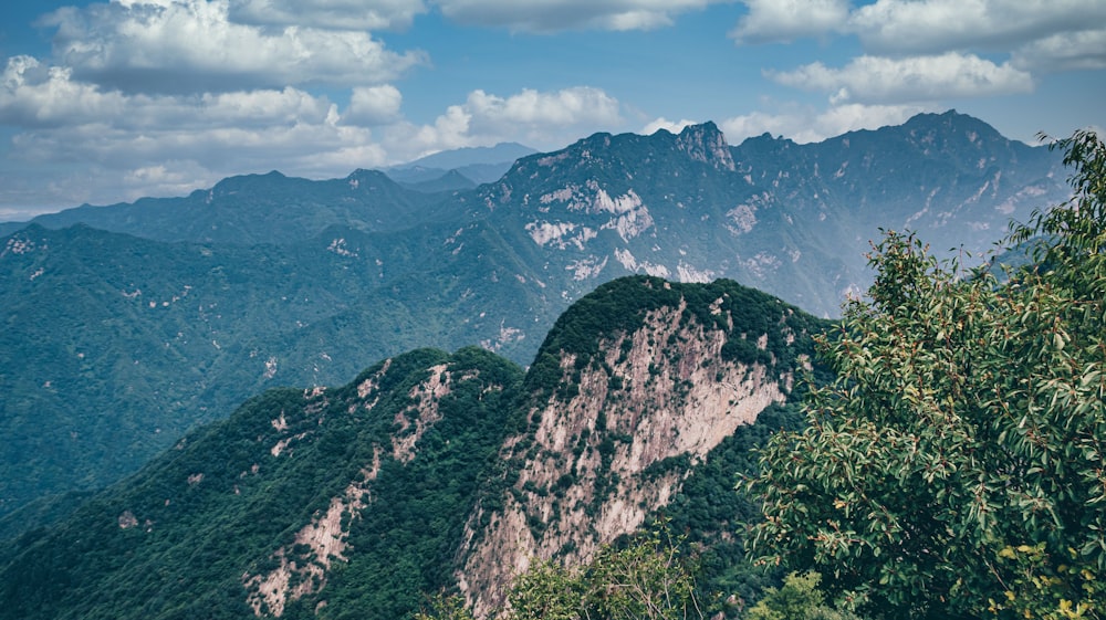 a view of a mountain range with trees and mountains in the background