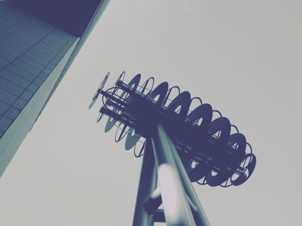 a tall metal object in front of a tall building