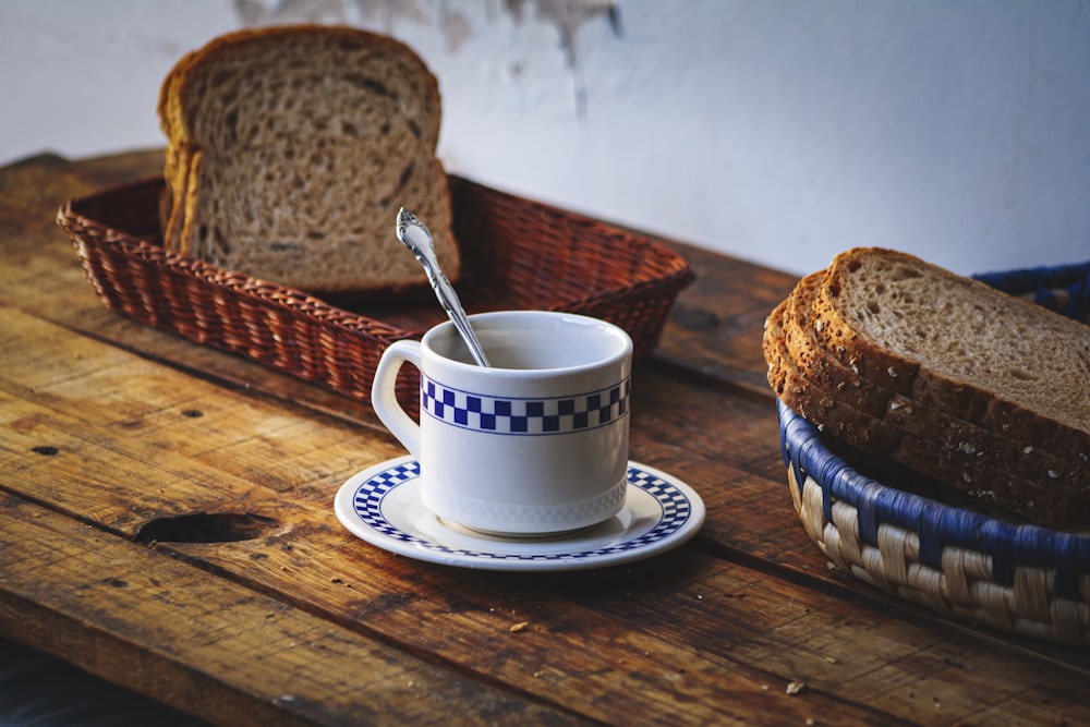 eine Tasse Kaffee neben einem Laib Brot