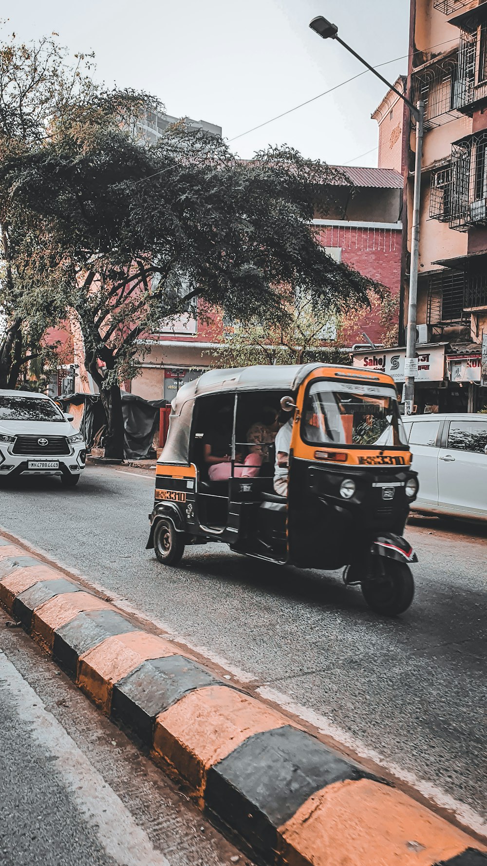 a tuk tuk driving down a city street