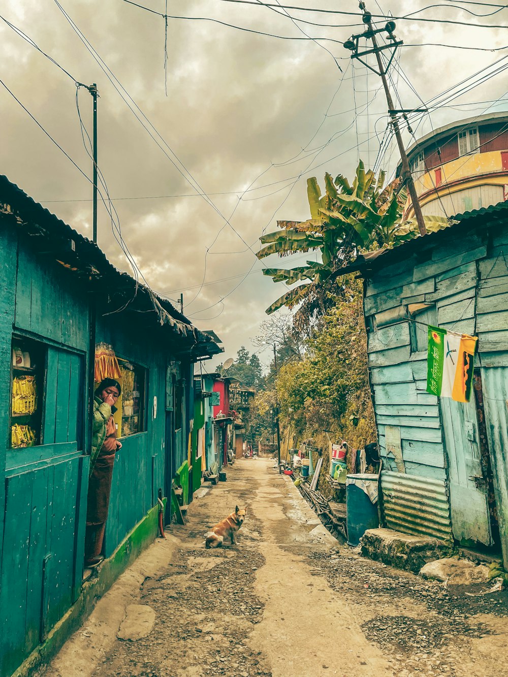 a dirt road next to a blue building