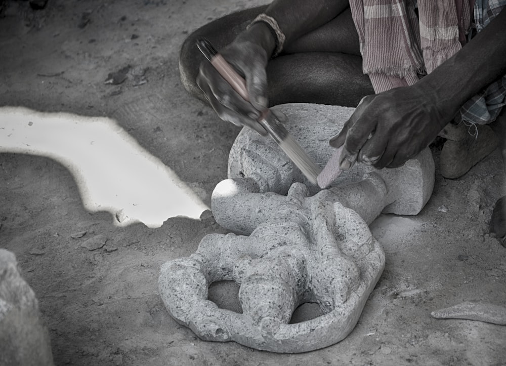 a man is carving a statue out of cement