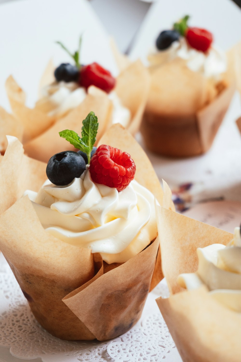 a close up of some cupcakes with fruit on top