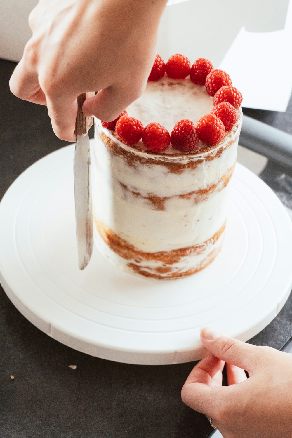 a person cutting a cake with a knife