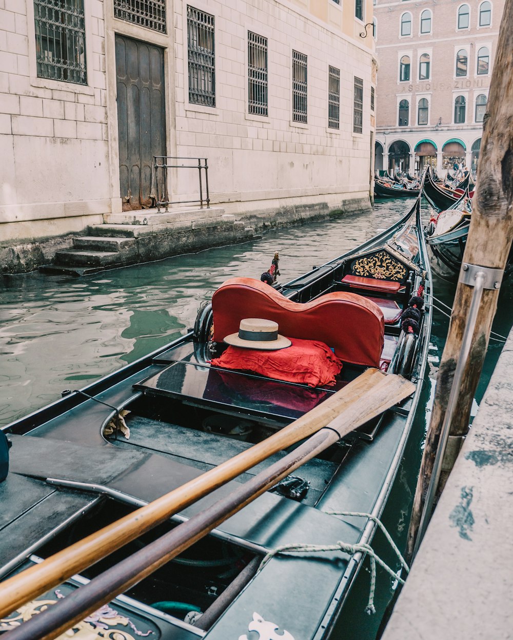 a row of gondolas in a canal with buildings in the background