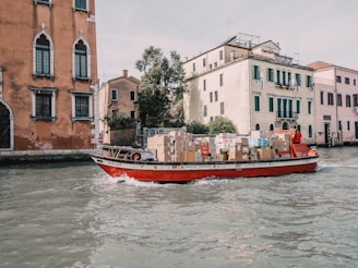a red boat with boxes on it in the water