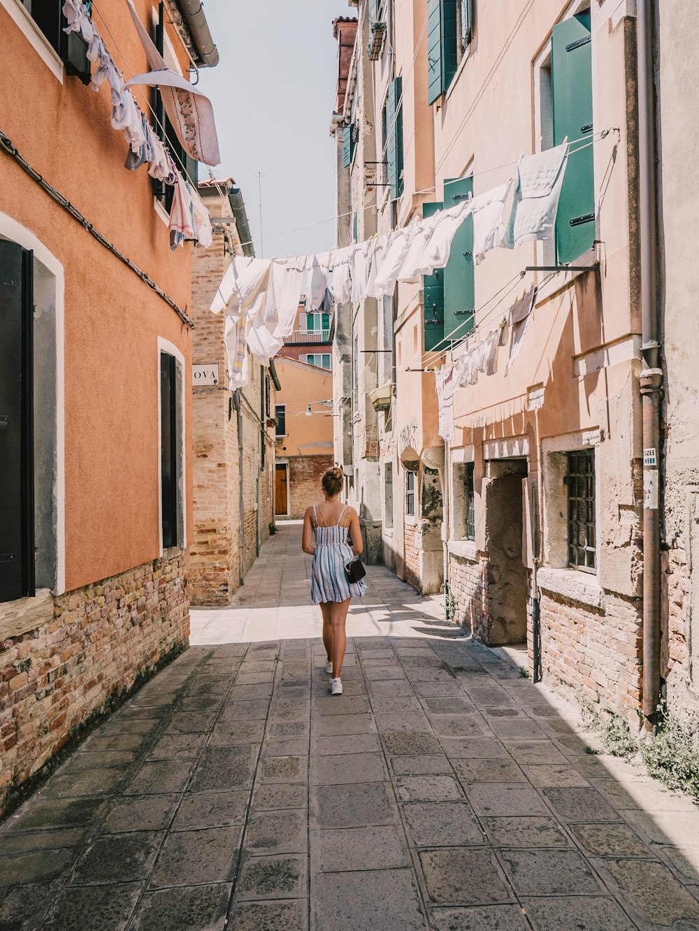 a woman walking down a street next to buildings