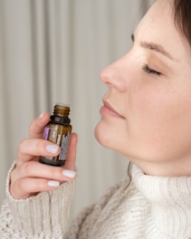 a woman holding a bottle of essential oils