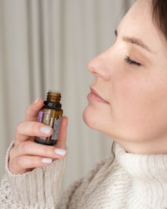 a woman holding a bottle of essential oils