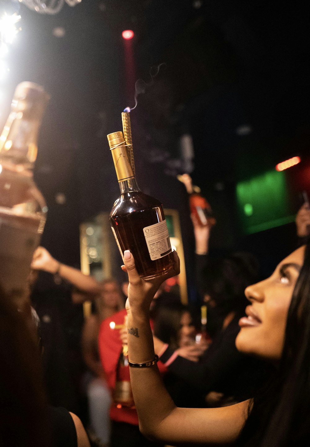 a woman holding up a bottle of liquor