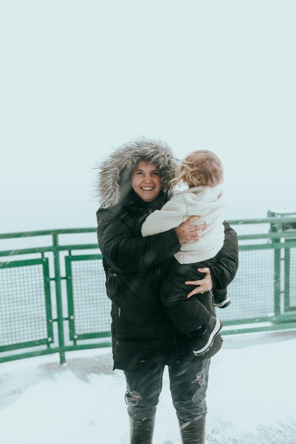 a woman holding a child in the snow