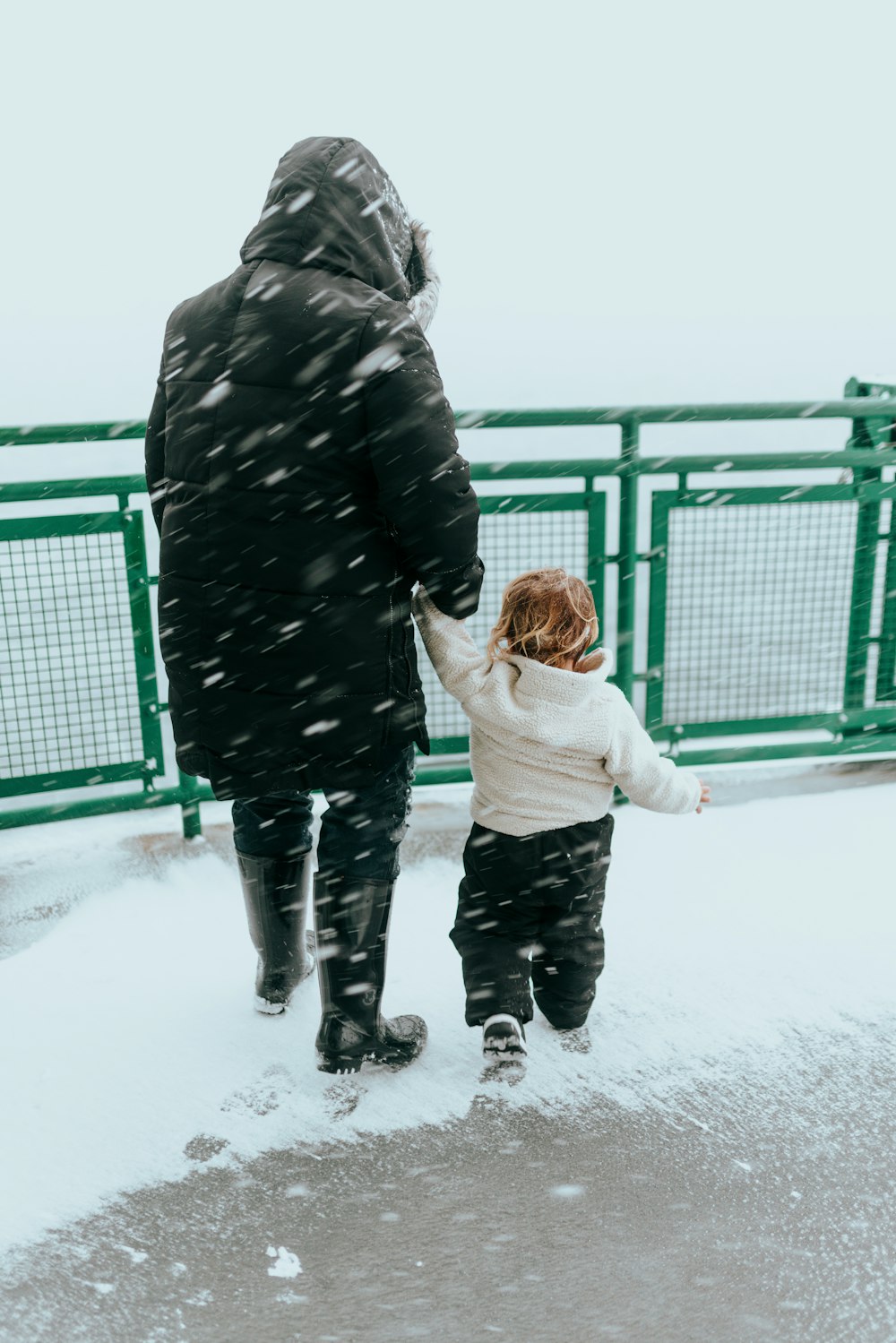 a man and a child walking in the snow