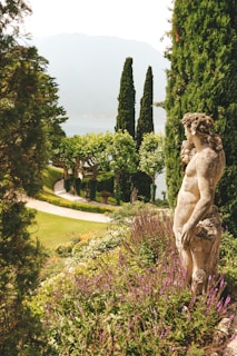 A serene landscape featuring a ceramic sculpture in a garden.