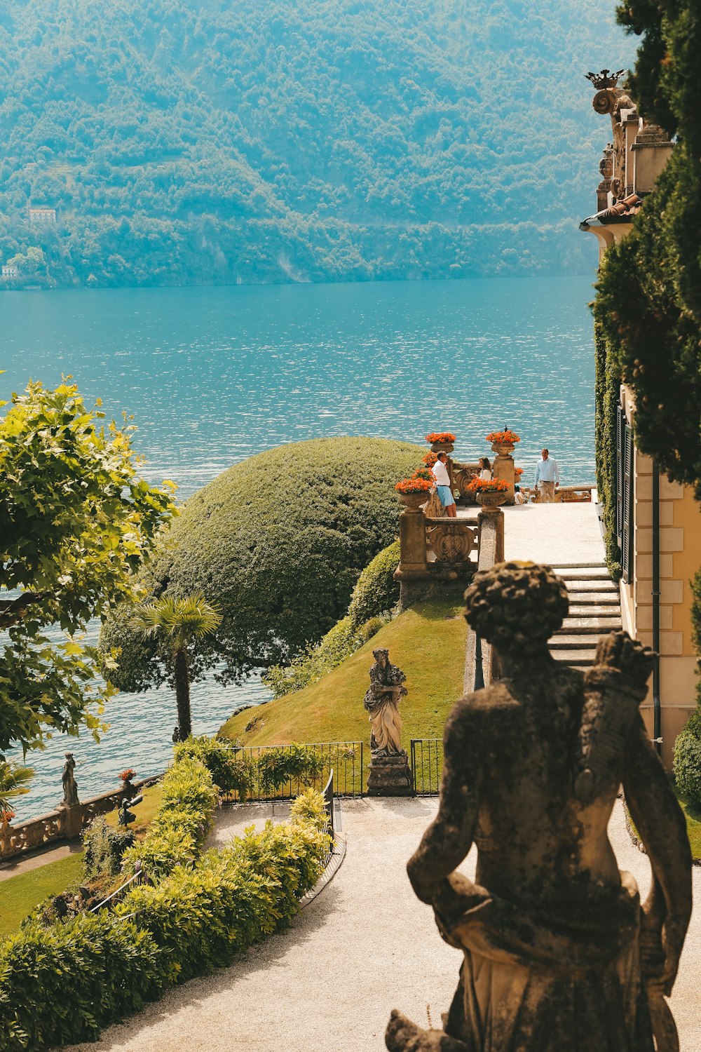 a statue in front of a large body of water