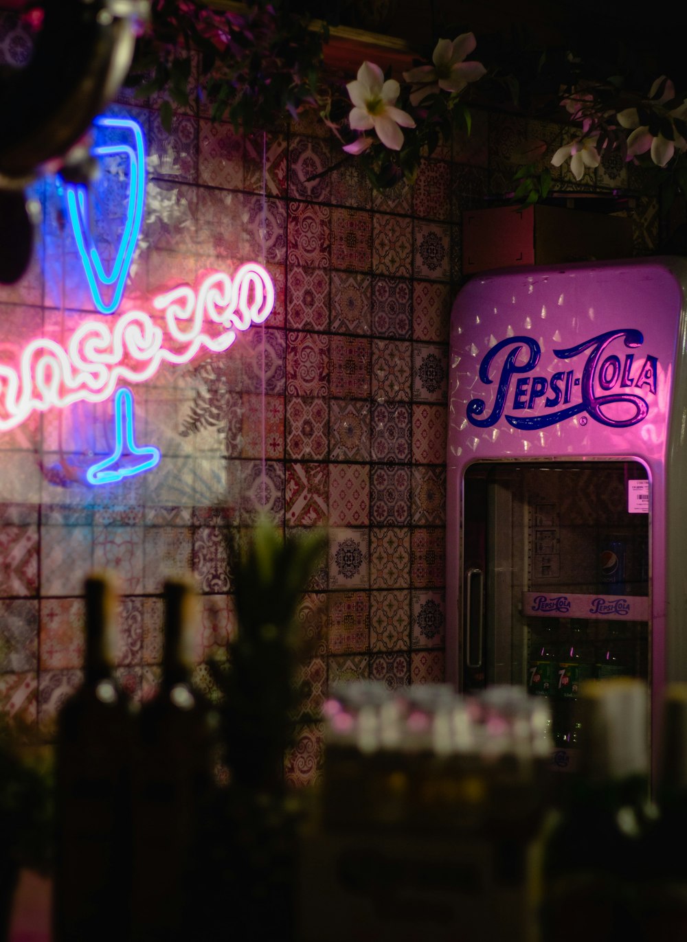 a pink pepsi cola machine sitting next to a wall